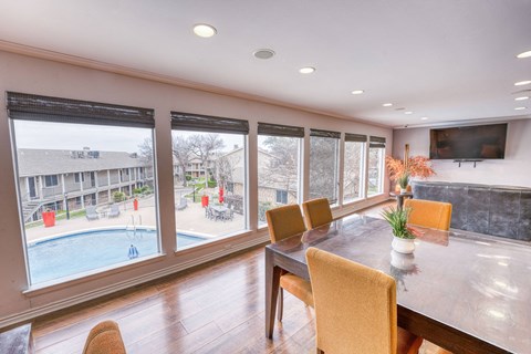 a dining room with a large window overlooking a swimming pool